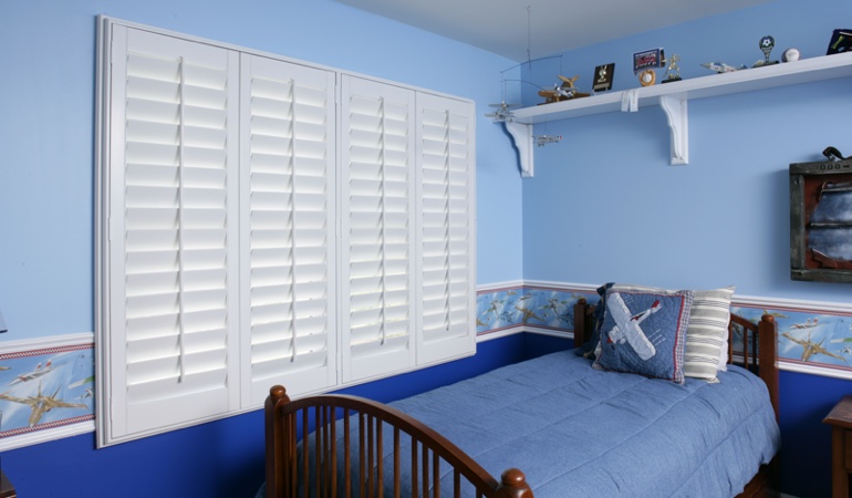 Blue kids bedroom with white plantation shutters in St. George 